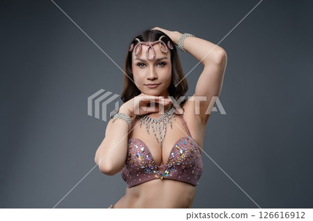 Elegant belly dancer showcasing intricate costume and graceful pose Elegant belly dancer showcasing intricate costume and graceful pose 126616912