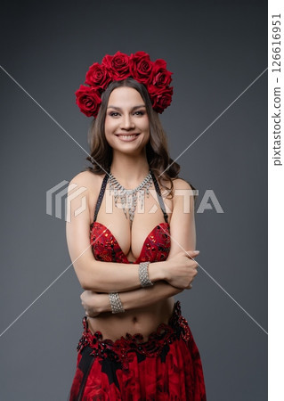 Woman in red outfit with floral headpiece poses confidently for the camera Woman in red outfit with floral headpiece poses confidently for the camera 126616951
