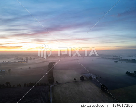 A Beautiful and Calm Sunrise Over the Misty Fields of the Countryside and Horizons A Beautiful and Calm Sunrise Over the Misty Fields of the Countryside and Horizons 126617296