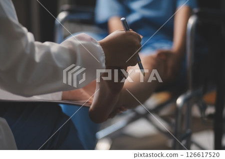 A female doctor examines an elderly patient with knee pain due to arthritis. The patient is being assisted in recovery, focusing on pain management and improving mobility. A female doctor examines an elderly patient with knee pain due to arthritis. The patient is being assisted in recovery, focusing on pain management and improving mobility. 126617520