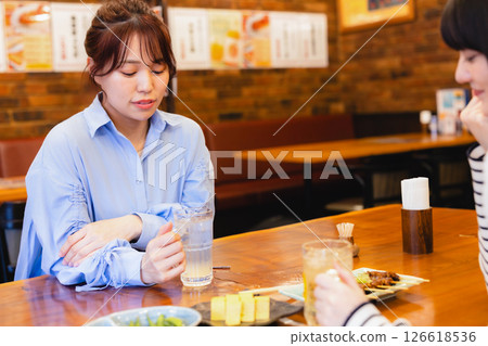 A woman drinking at a pub A woman drinking at a pub 126618536