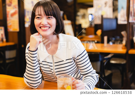 A woman drinking at a pub 126618538