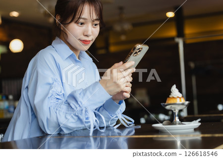 A woman using a smartphone in a cafe A woman using a smartphone in a cafe 126618546