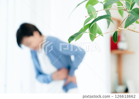 Middle-aged woman suffering from stomach pain Middle-aged woman suffering from stomach pain 126618662