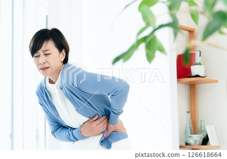 Middle-aged woman suffering from stomach pain Middle-aged woman suffering from stomach pain 126618664