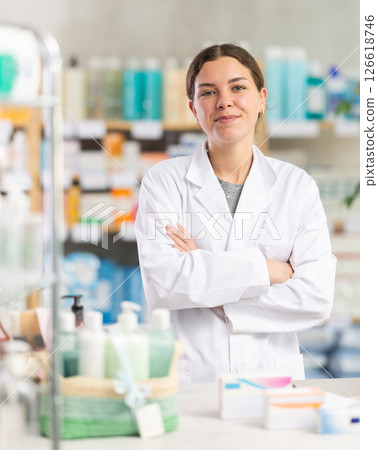 Woman pharmacist standing in pharmacy and smiling 126618746