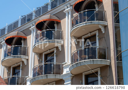 Facade of a multi story building with mirrored windows and balconies. 126618798
