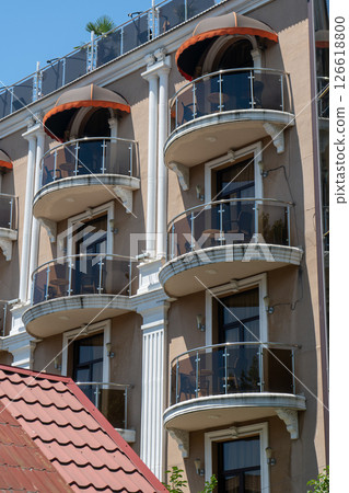 Facade of a multi story building with mirrored windows and balconies. Facade of a multi story building with mirrored windows and balconies. 126618800