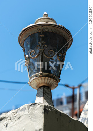 Street lamp with an antique lampshade against the blue sky. 126618804