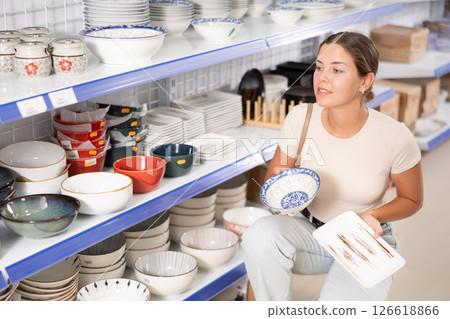 Young woman choosing plates in store 126618866
