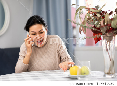 Asian woman swears at someone while talking on a mobile phone Asian woman swears at someone while talking on a mobile phone 126619039