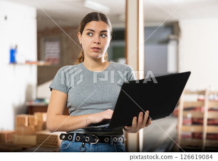 Female designer working with laptop in apartment under renovation 126619084