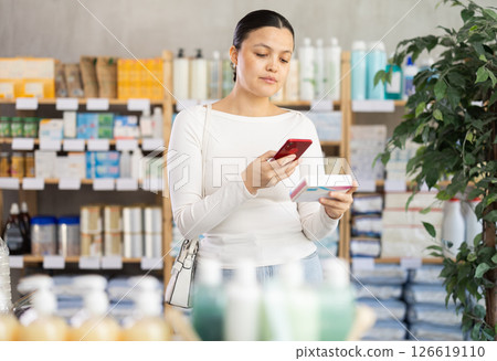 Asian woman scans qr code on pill pack 126619110