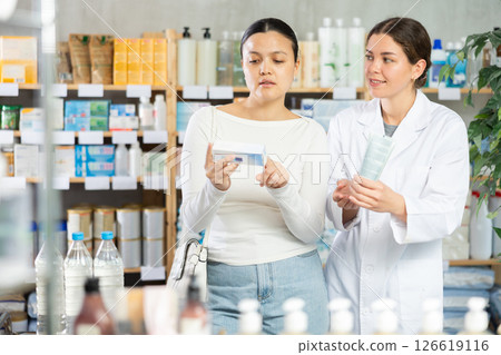 Concerned woman asking pharmacist to recommend suitable ointment Concerned woman asking pharmacist to recommend suitable ointment 126619116