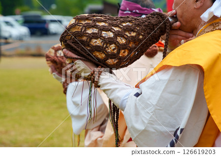 Yamabushi blowing a conch horn at the fire-walking festival 126619203
