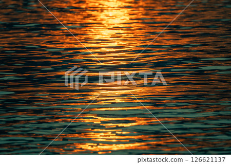 Summer Sunset Over the Water ,sun setting low over the ocean water on a summer evening 126621137