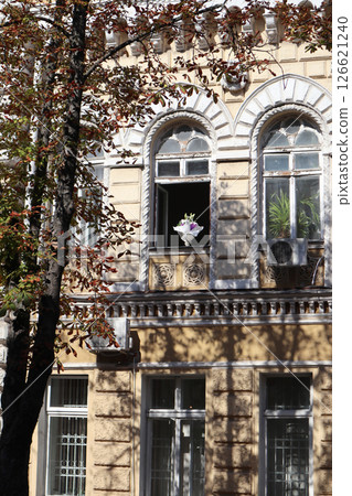Bouquet of flowers at window of historic building. 126621240