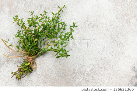 Fresh thyme bunch tied with twine on gray background for culinary use Fresh thyme bunch tied with twine on gray background for culinary use 126621360