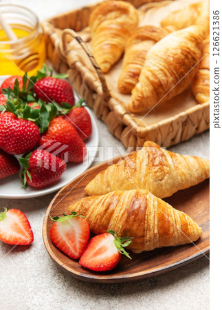 Delicious french croissants with fresh strawberries and honey for breakfast Delicious french croissants with fresh strawberries and honey for breakfast 126621386
