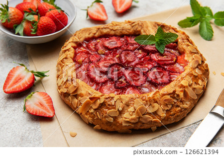 Delicious homemade strawberry galette with almond petals and fresh mint 126621394