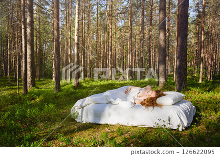 Woman sleeps on a mattress in the summer forest 126622095