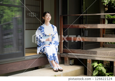 A woman in a yukata relaxing on the veranda of an old house 126622124