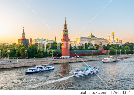 View of Kremlin with Vodovzvodnaya tower, Grand Kremlin Palace from repaired Bolshoy Kamenny Bridge in Moscow city on sunny summer day. Cruise ship sails on the Moscow river 126623305