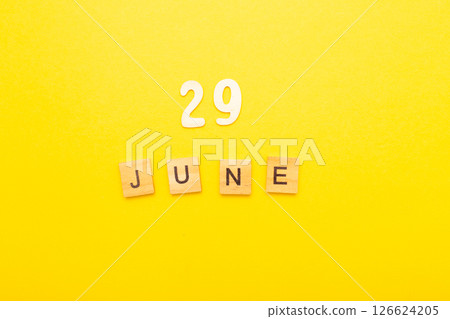 Top view of word 29 June calendar date made by wooden cubes on yellow color background Top view of word 29 June calendar date made by wooden cubes on yellow color background 126624205