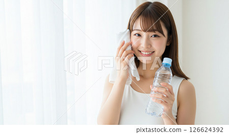 A young woman hydrates herself to prevent heatstroke A young woman hydrates herself to prevent heatstroke 126624392