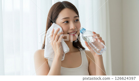 A young woman hydrates herself to prevent heatstroke A young woman hydrates herself to prevent heatstroke 126624397