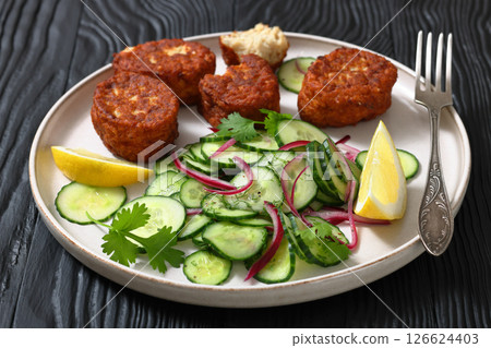 dutch fish cakes with cucumber salad on a plate dutch fish cakes with cucumber salad on a plate 126624403