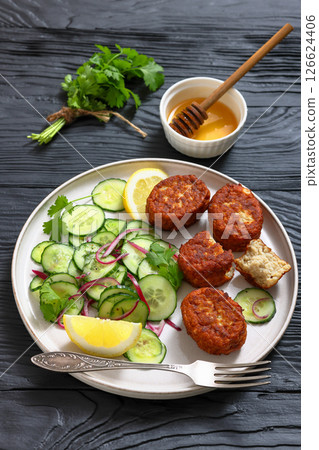 dutch fish cakes with cucumber salad on a plate 126624406