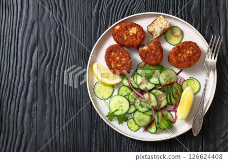 dutch fish cakes with cucumber salad on a plate dutch fish cakes with cucumber salad on a plate 126624408