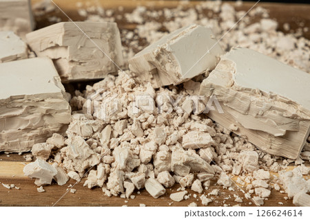 Compressed fresh yeast cubes close-up on a wooden background. 126624614