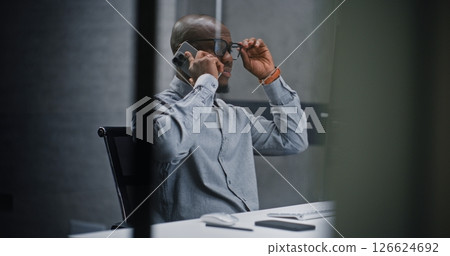 Professional Investment Agent Using Computer and Talking on Cellphone in Financial Agency Office 126624692