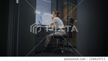 Stressed Female Financial Analyst Talking on Phone, Analyzing Exchange Market Charts 126624711