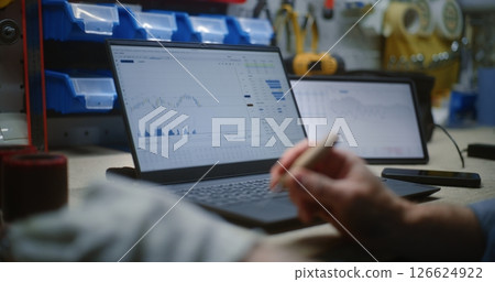 Craftsman Doing Handwork, Monitoring Stocks on Laptop and Tablet Computer in Workshop Craftsman Doing Handwork, Monitoring Stocks on Laptop and Tablet Computer in Workshop 126624922