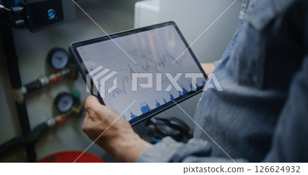 Employee Checking Real-Time Stocks Using Digital Tablet in Workshop Employee Checking Real-Time Stocks Using Digital Tablet in Workshop 126624932