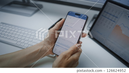 Female Financial Analyst Checking Real-Time Stocks on Smartphone and Tablet Computer 126624952