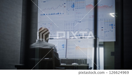 Stock Exchange Trader Monitoring Exchange Market Charts on Computer with Multi-Monitor Desktop Setup 126624969