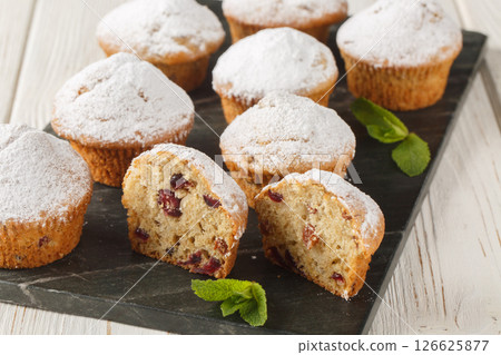Christmas muffin stollen with powdered sugar, raisins, candied fruits closeup on the board. Horizontal Christmas muffin stollen with powdered sugar, raisins, candied fruits closeup on the board. Horizontal 126625877