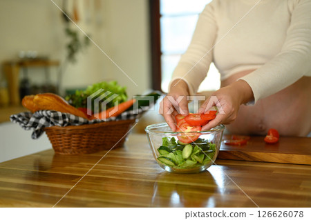 Pregnant woman preparing a healthy salad in a bright kitchen 126626078