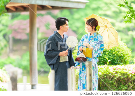 A couple in yukata walking through a Japanese garden 126626090