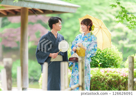 A couple in yukata walking through a Japanese garden A couple in yukata walking through a Japanese garden 126626091