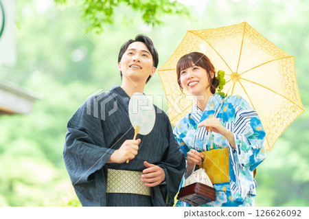 A couple in yukata walking through a Japanese garden 126626092