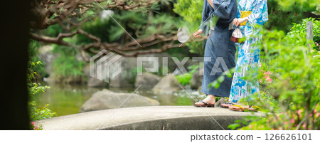 A couple in yukata walking through a Japanese garden A couple in yukata walking through a Japanese garden 126626101