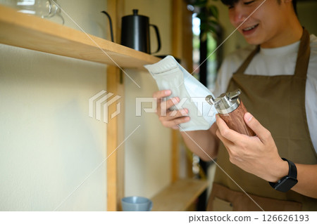 Man selecting beans and grinder for a perfect home brew experience Man selecting beans and grinder for a perfect home brew experience 126626193