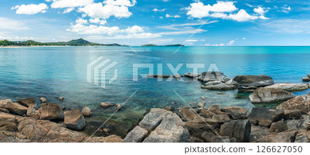 tropical island under the warm summer sun. The vibrant turquoise sea contrasts with fine white stone beaches 126627050