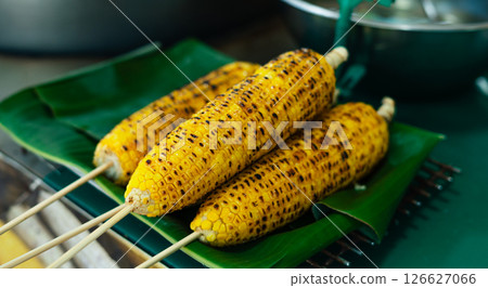 Fragrant Grilled Corn,three grilled corn cobs resting on a fresh green banana leaf Fragrant Grilled Corn,three grilled corn cobs resting on a fresh green banana leaf 126627066