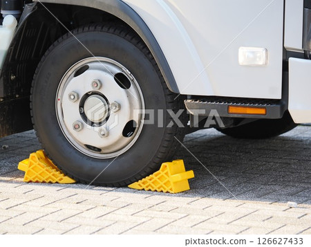 Wheel chocks placed on truck tires 126627433